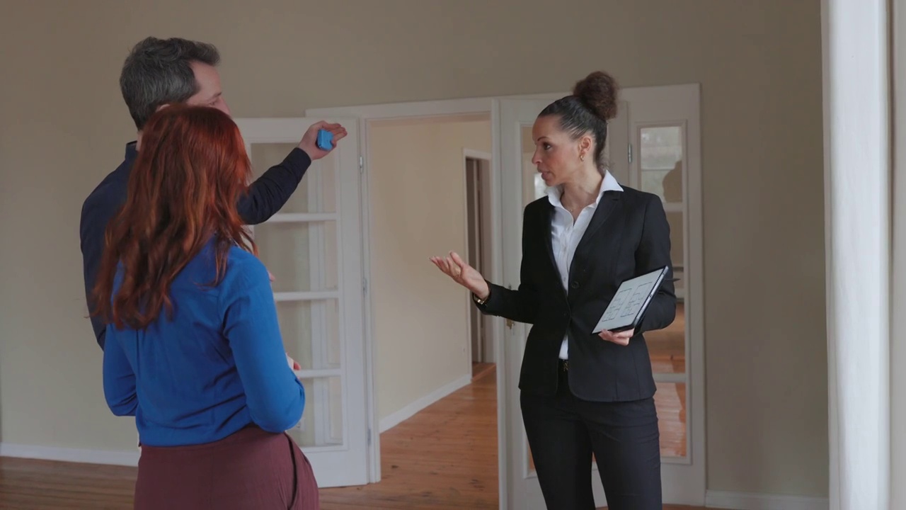 房地产经纪人使用数字平板电脑与潜在买家讨论房产细节视频下载