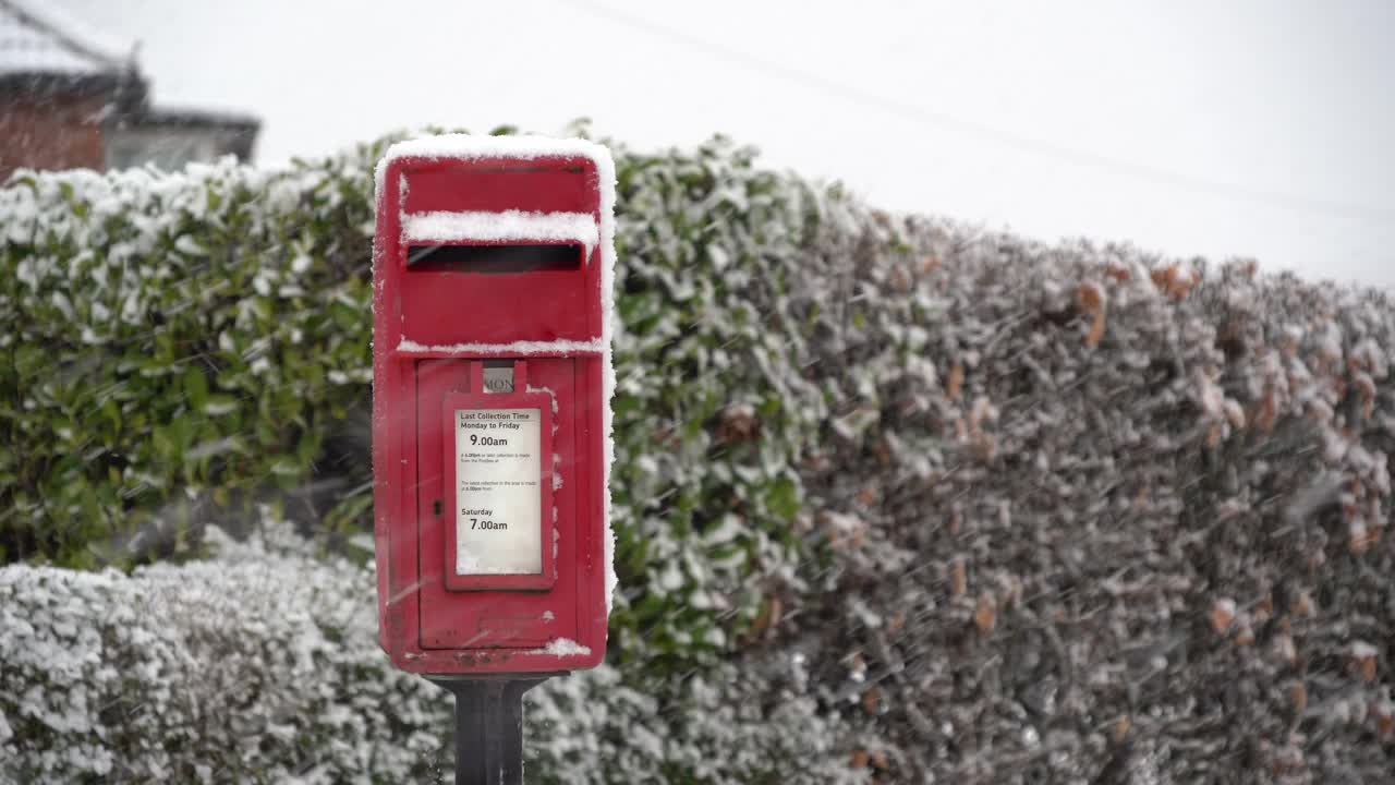 村子里的红色信箱在飘落的雪中视频素材