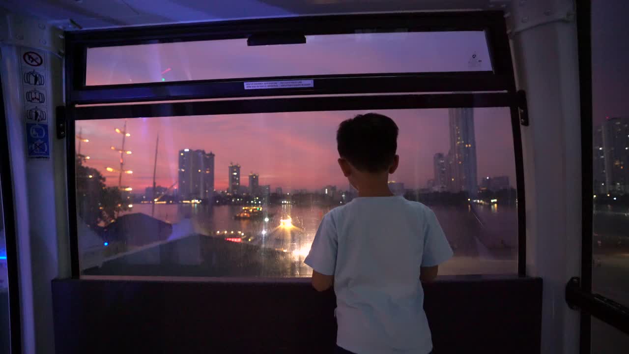 亚洲小孩晚上在曼谷的摩天轮上。假期和梦想的概念视频下载