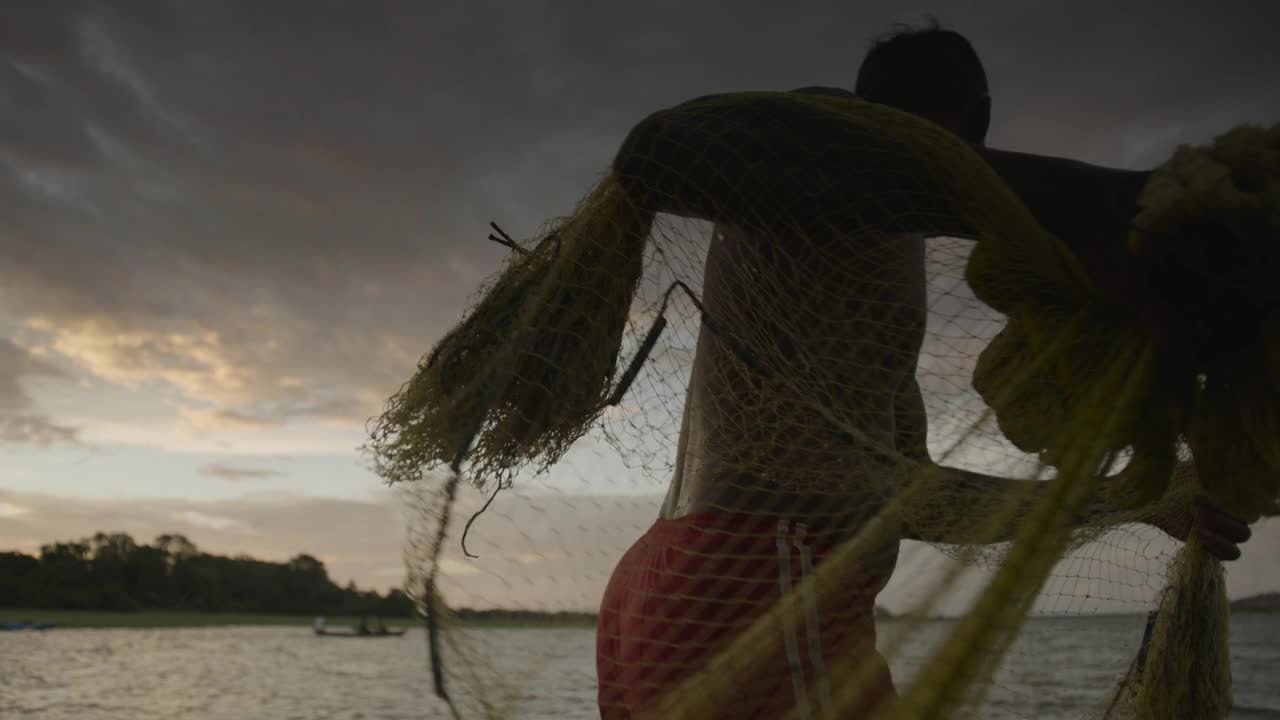 斯里兰卡，一名男子将渔网扔进水里。视频下载