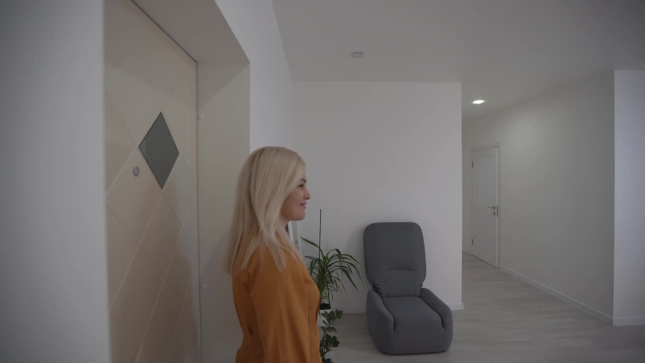 搬进新公寓，女人拿着钥匙走进她的新公寓，空荡荡的白色房间，新房建设。视频下载