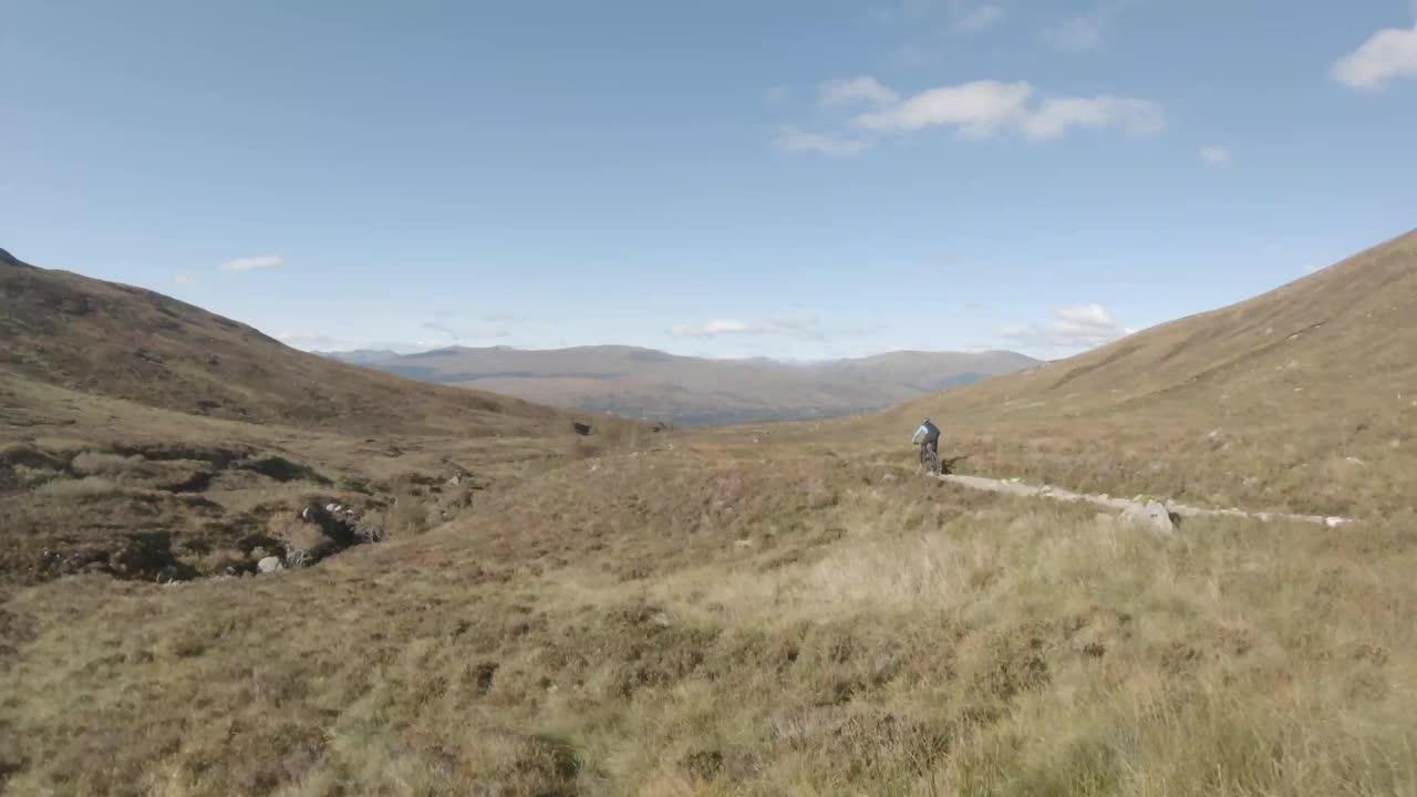 无人机拍摄到一名男性山地自行车手沿着山地自行车道快速骑行视频素材