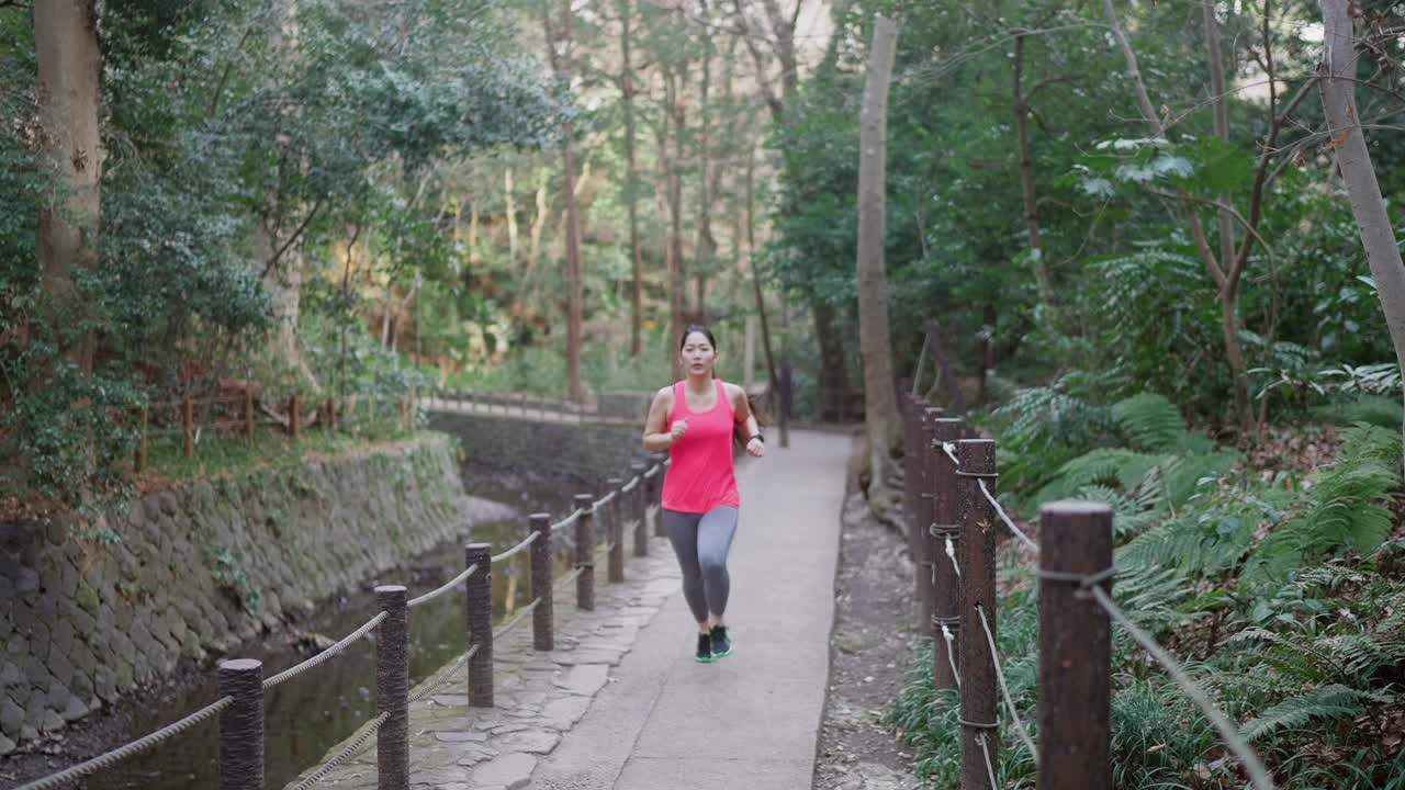年轻的女运动员在公园里跑步视频素材