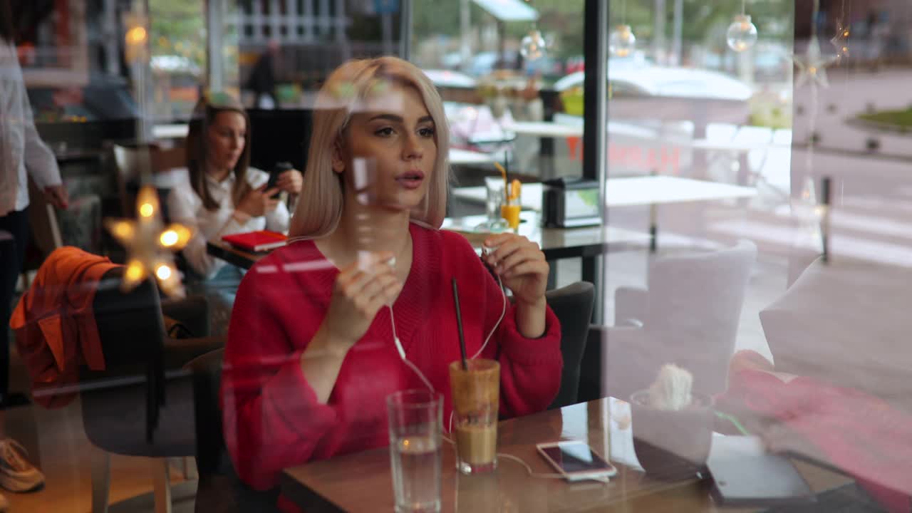 年轻女子在咖啡店喝咖啡视频下载