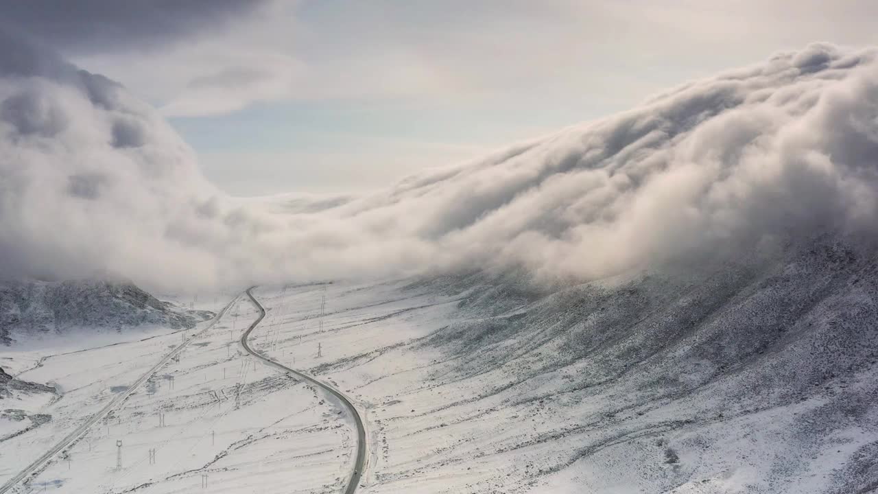 云瀑从山顶倾泻而下，淹没了山谷的道路视频素材