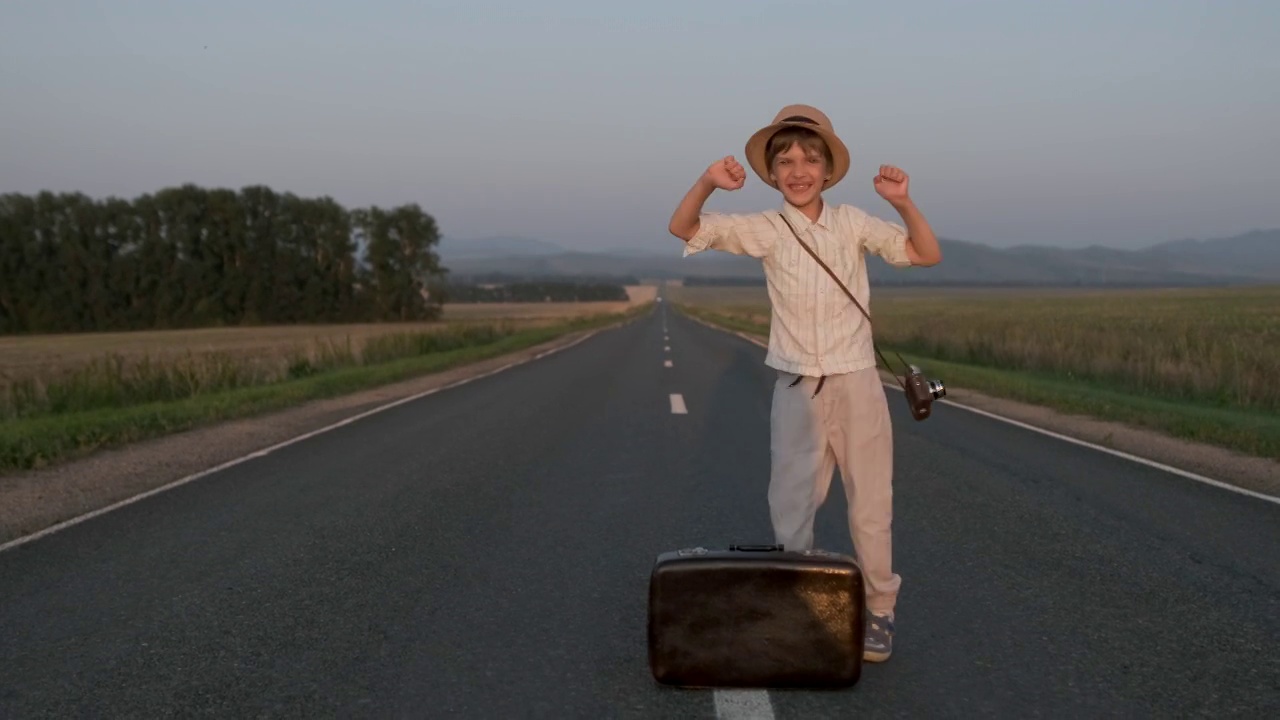 快乐的小男孩戴着帽子和手提箱跳舞视频下载
