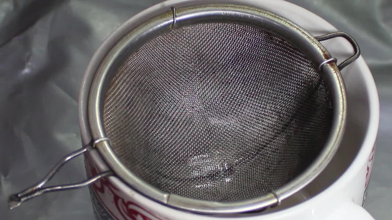 用金属滤茶器或滤茶器将热红茶倒入杯中。视频下载