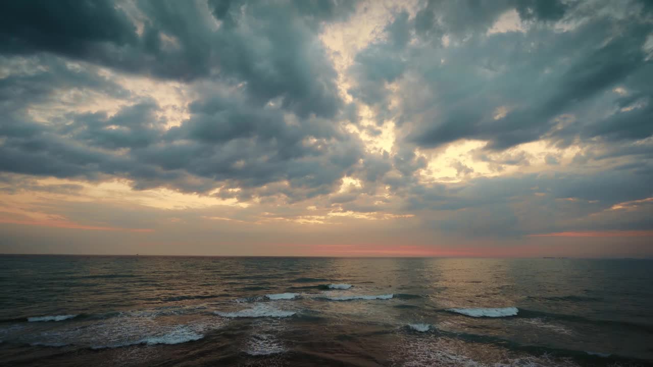 戏剧性的天空云图在晚上海面上方直到地平线，海浪移动与云视频素材