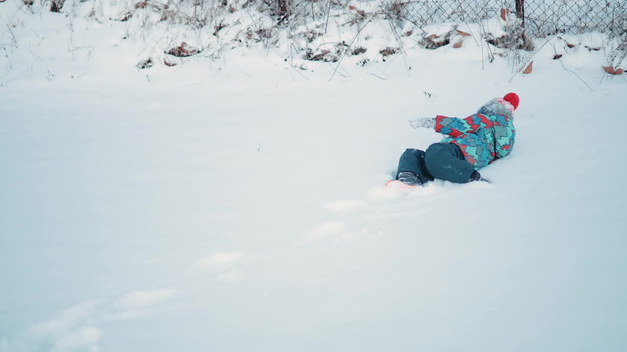 顽皮的小男孩在雪地里打滚视频下载