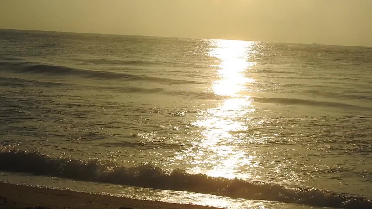 海面上的小波浪日落。金色的夕阳和黄色的阳光。《海边的日落》美丽的海上日落。日落与海浪视频素材