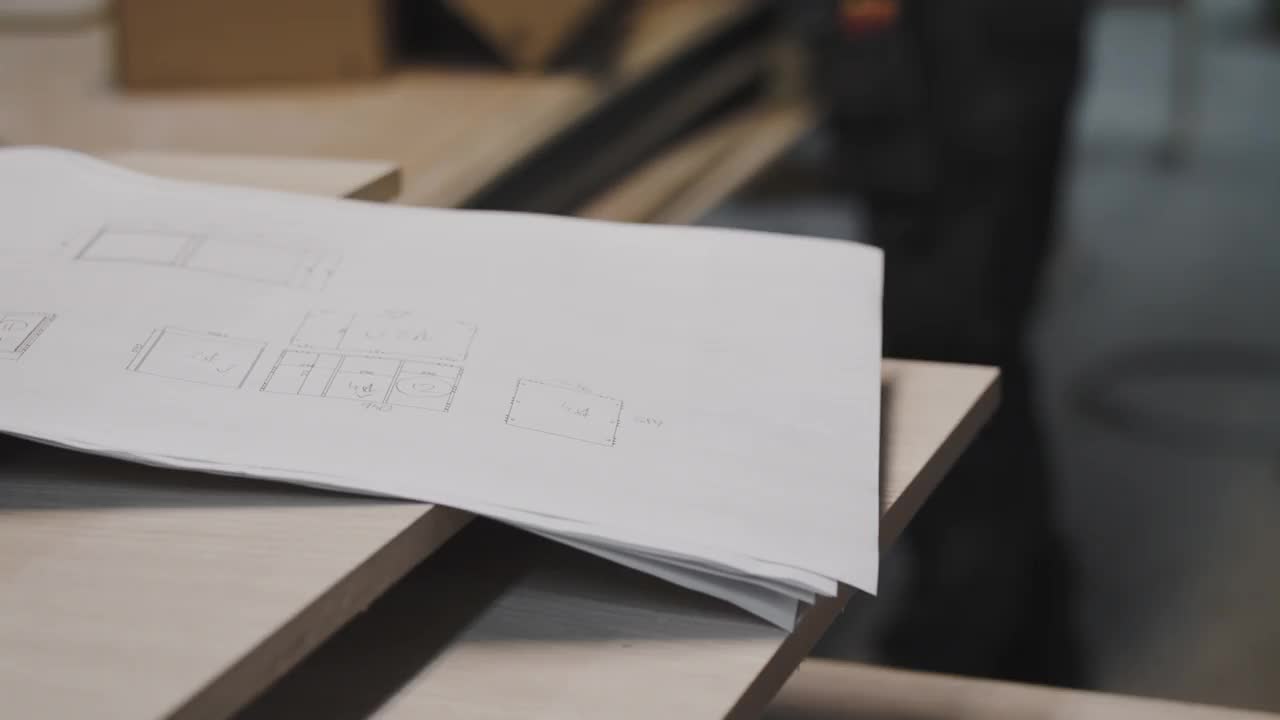 手持式拍摄设计纸上的木板由女木匠包装设备在纸箱在工作台上视频素材
