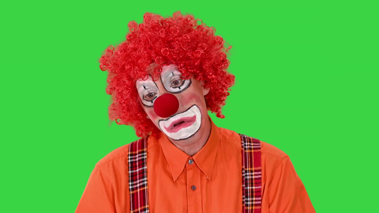 小丑与不快乐的表情在他的脸上走在一个有趣的方式在绿色屏幕，色度键视频素材