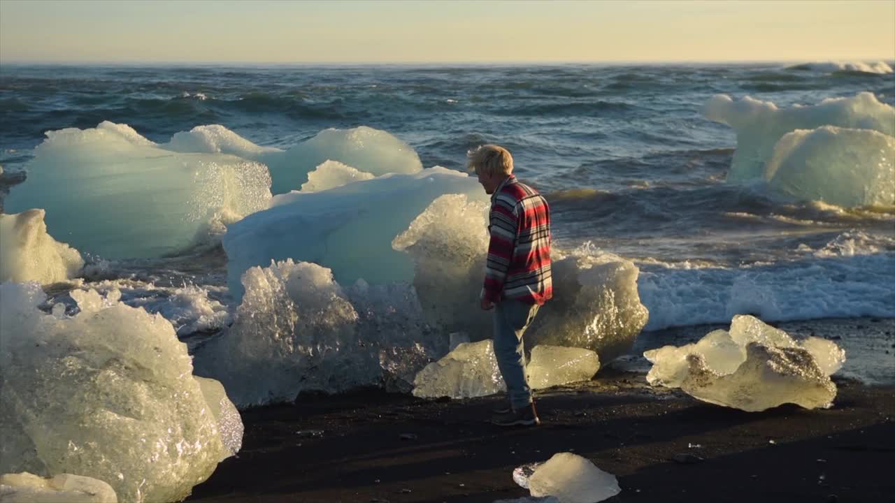 日落时分，冰山密布的钻石海滩，人们在欧洲的冰岛漫步。视频素材