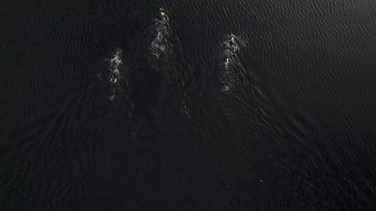 无人机拍摄的开放水域游泳者在一个苏格兰湖游泳视频下载