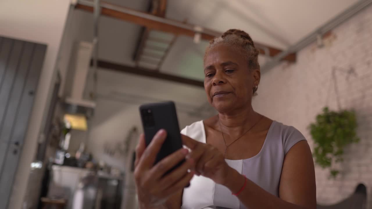 在家里使用智能手机的资深女性视频下载