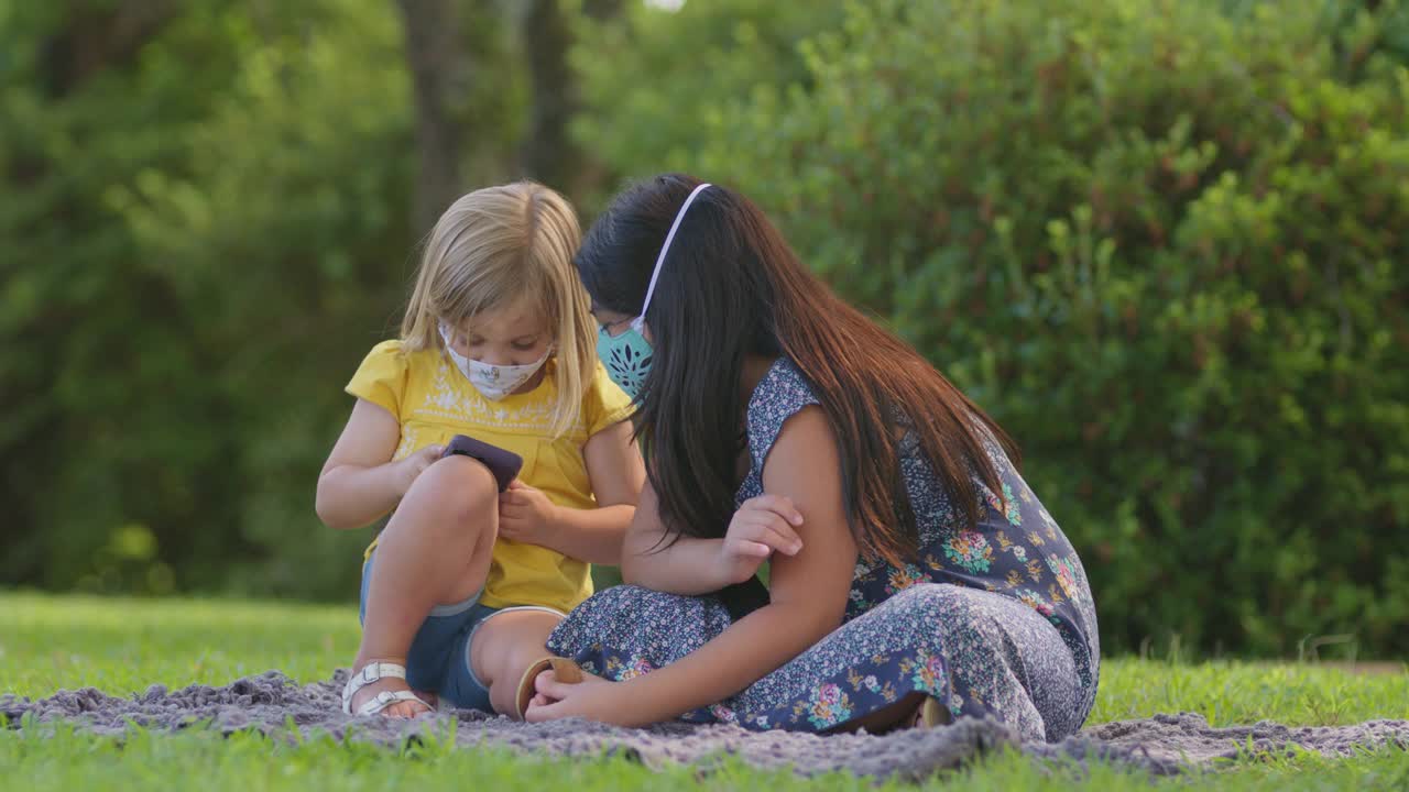 小女孩戴着防护口罩给朋友拍照的SLO MO视频素材