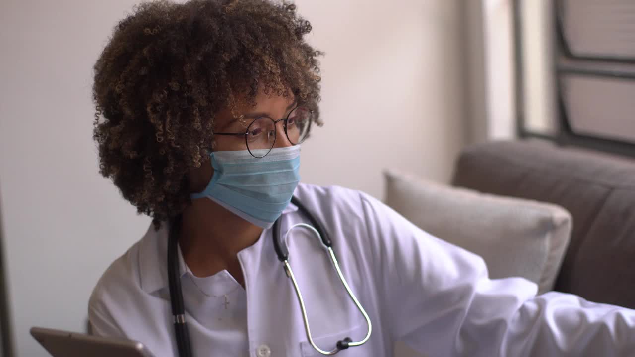 医生在家访中安慰成熟的病人-使用口罩视频素材