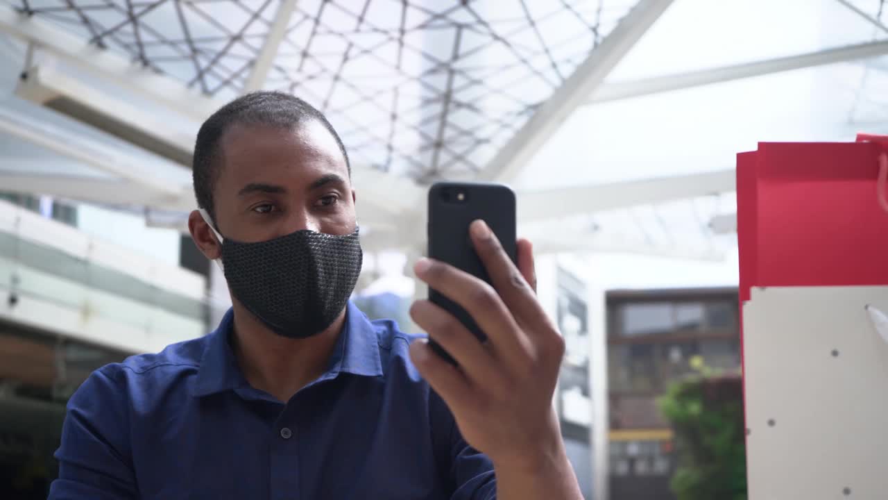 一个戴着面具的男人用他的手机打视频电话视频素材