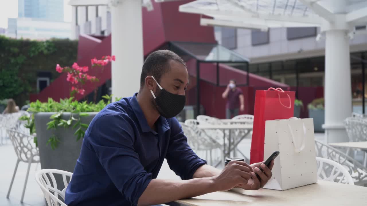 一个戴着面具的男人用他的手机打视频电话视频素材