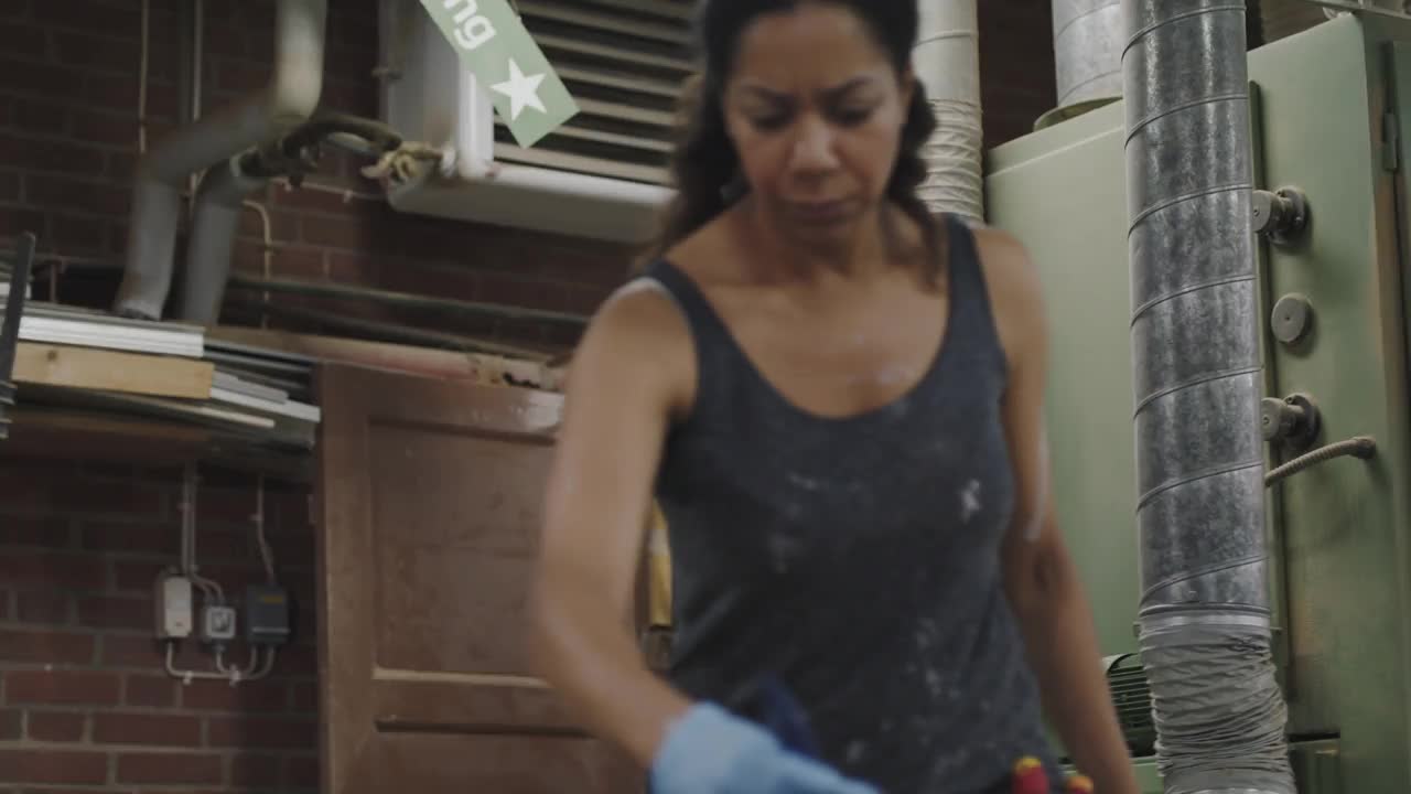 手持式拍摄自信的女工匠在车间的木板上涂清漆视频下载
