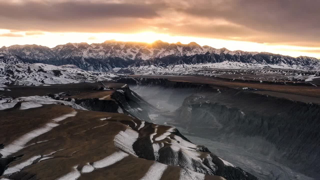 峡谷被雾覆盖着，一直通向雪山。太阳从雪山的山顶升起视频素材