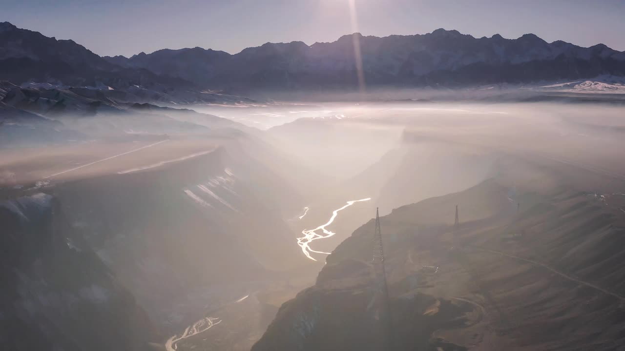 薄雾笼罩着峡谷，谷底的河流反射着阳光视频素材