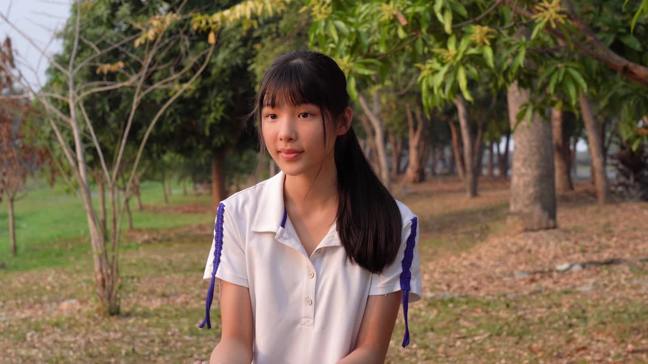 亚洲年轻女子的面部表情，拟人化的笑脸，招手手势视频素材