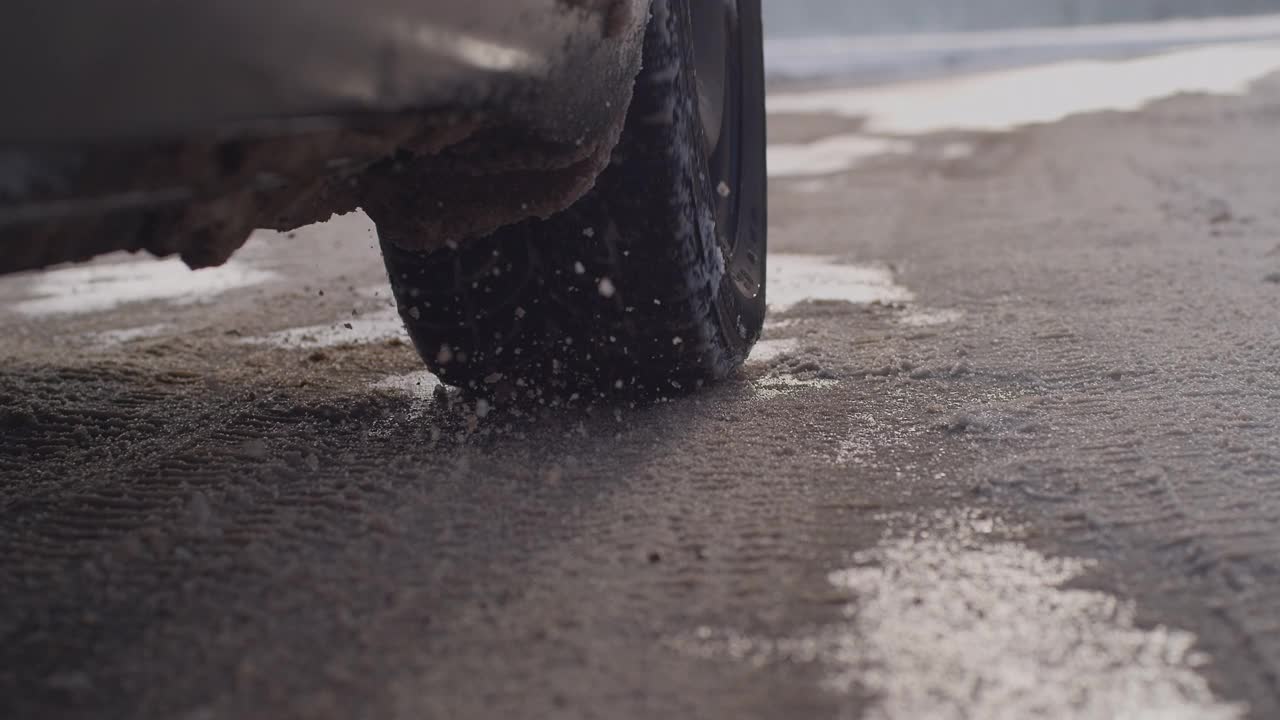汽车在雪地上行驶的轮胎靠近了视频下载