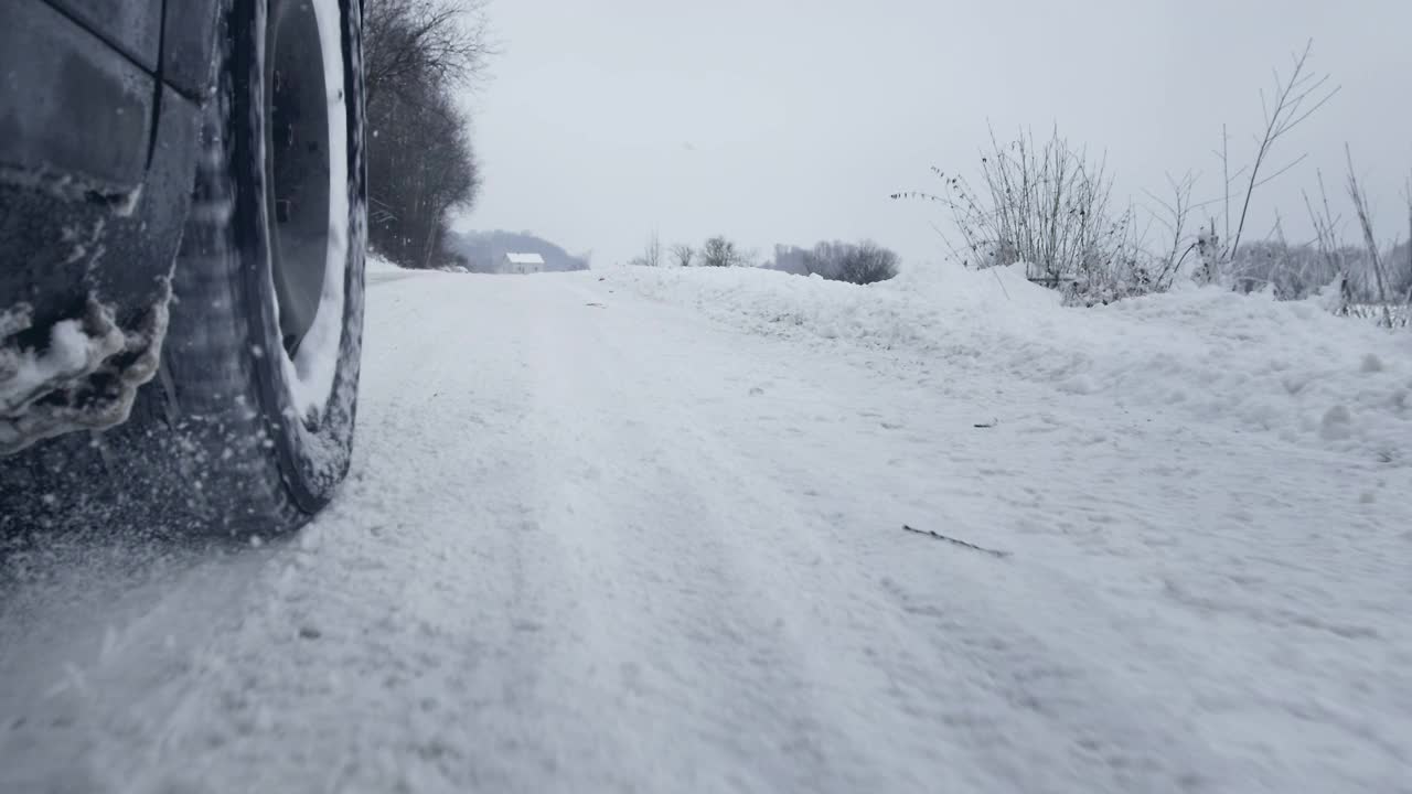汽车在雪地上行驶的轮胎靠近了视频下载
