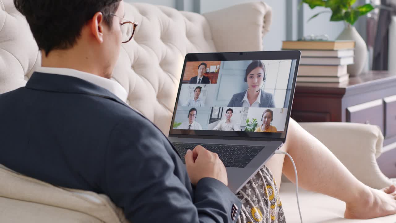 年轻的亚洲搞笑商人穿着内衣在家里工作，与同事们进行虚拟视频会议，在线工作，在家里进行视频通话视频素材