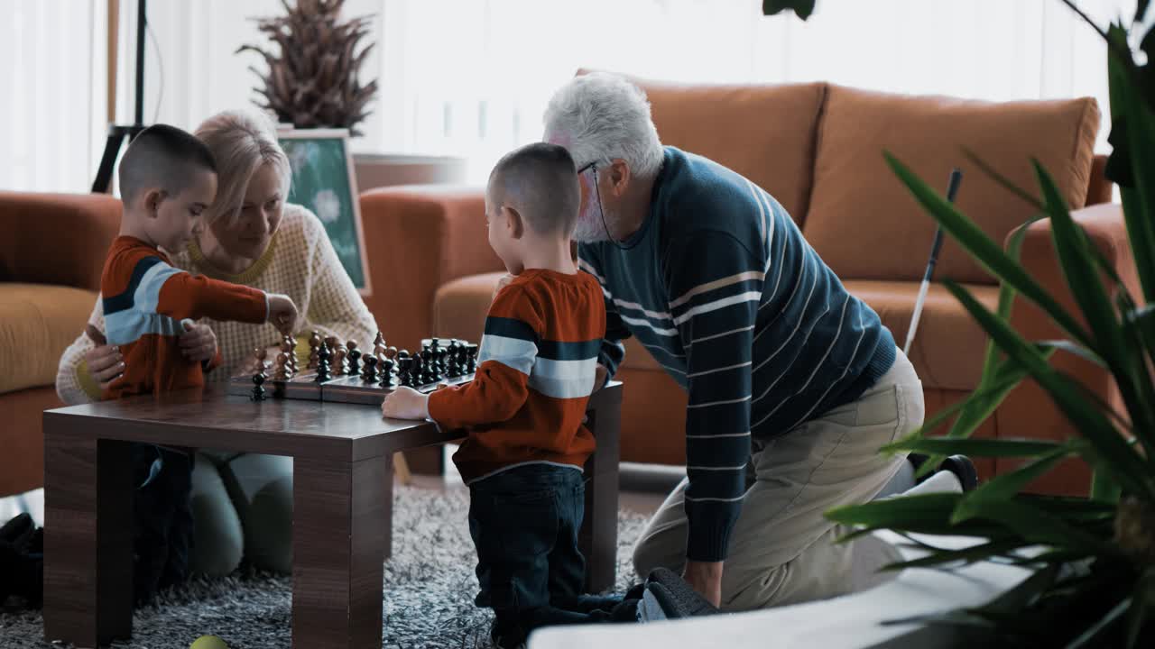 小双胞胎男孩在家里和爷爷奶奶下棋，长辈积极。视频素材