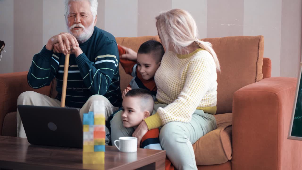 双胞胎小男孩和他们的奶奶一起抓老人的后背。祖父母和孙辈使用笔记本电脑。一个白发老人拿着一根棍子视频素材