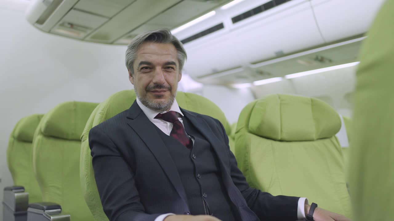 一个成熟的商人坐在飞机上的肖像视频下载