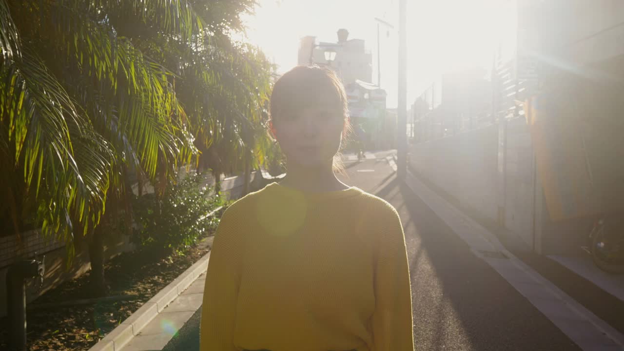 穿着黄色毛衣走在街上的漂亮女人的肖像视频素材