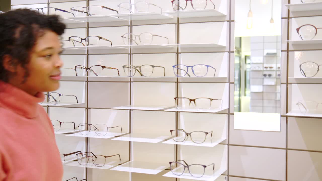 女顾客在眼镜店试戴新眼镜视频素材