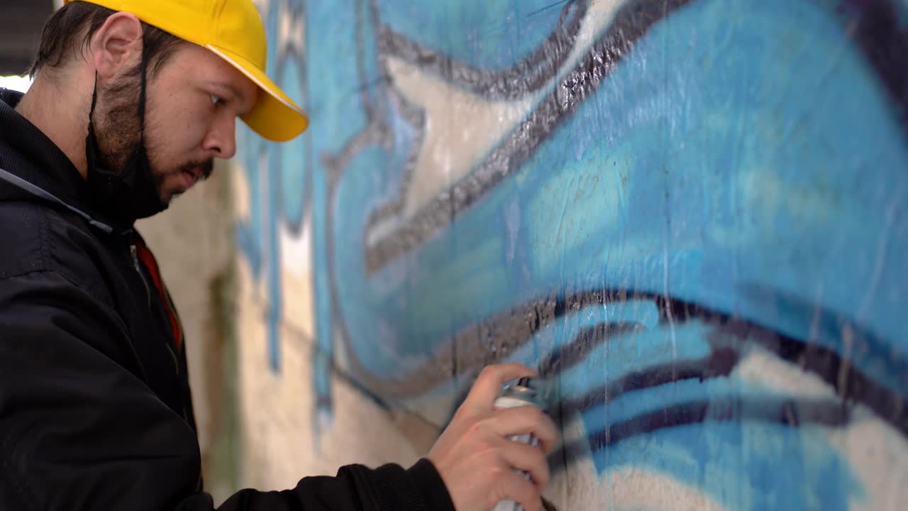 街头艺术家在公共墙壁上画彩色涂鸦的细节视频下载