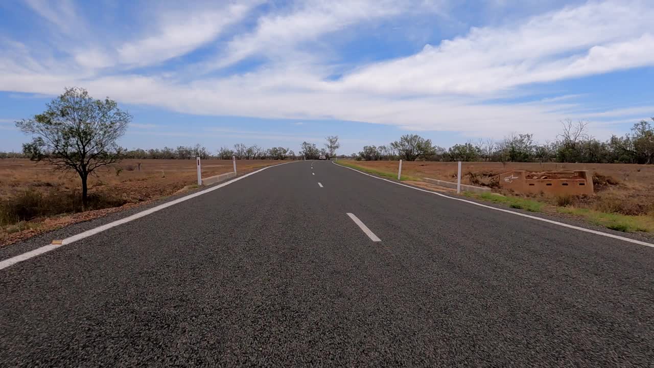 行驶在空旷的乡村公路上，没有树木，平原，蓝天和白云，澳大利亚视频素材