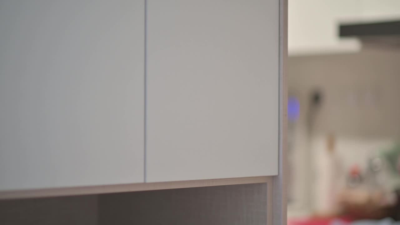 一名亚洲华裔男子从厨房的架子上取食瓶视频素材