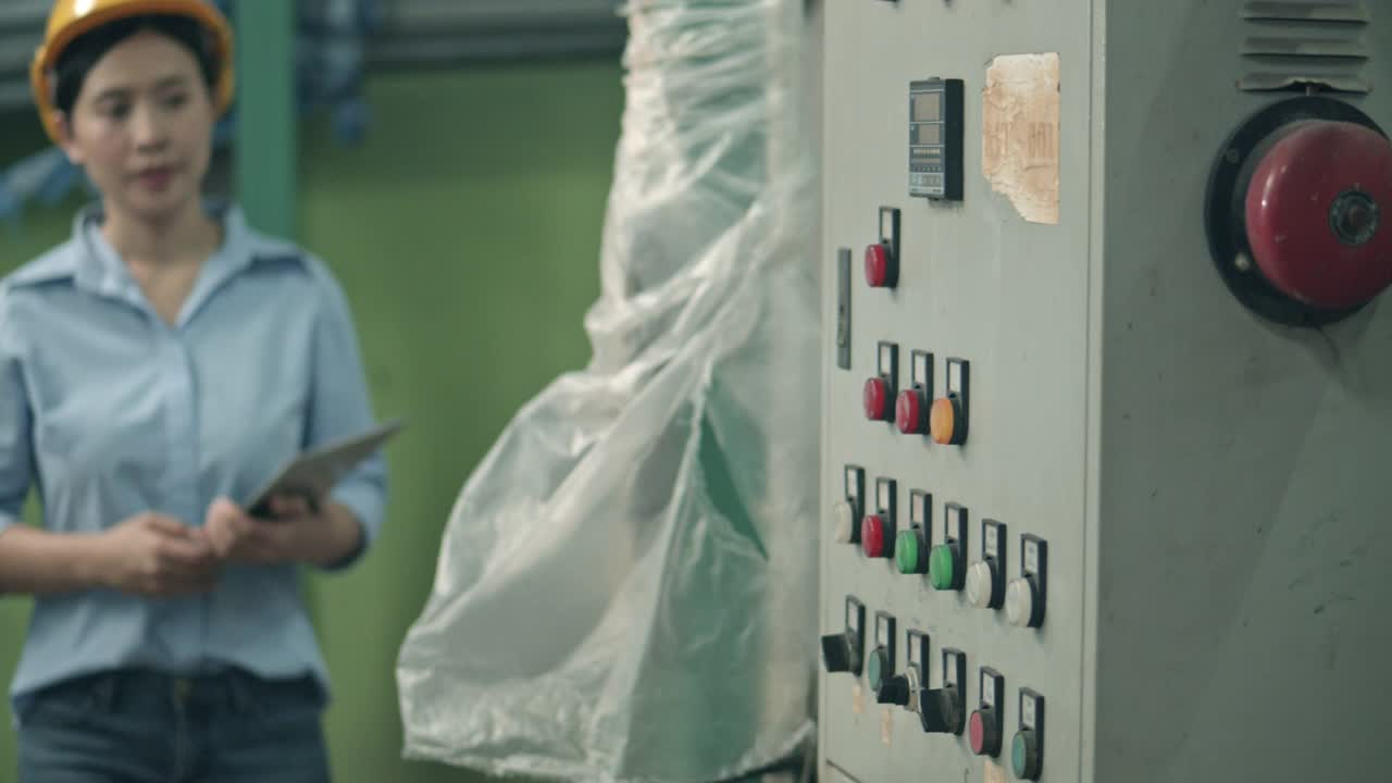 身着安全制服的女工程人员在食品加工厂用手提电脑进行质控机械检查视频素材