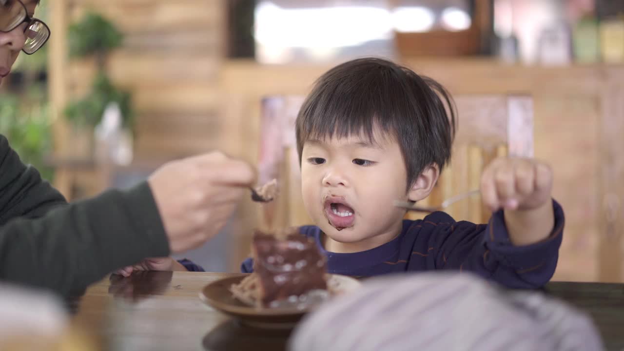 亚洲母亲和男婴在蛋糕店吃巧克力蛋糕视频下载