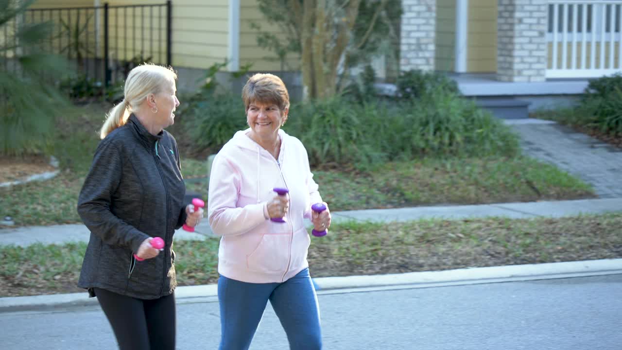 两个老年妇女边走边用哑铃，笑着视频下载