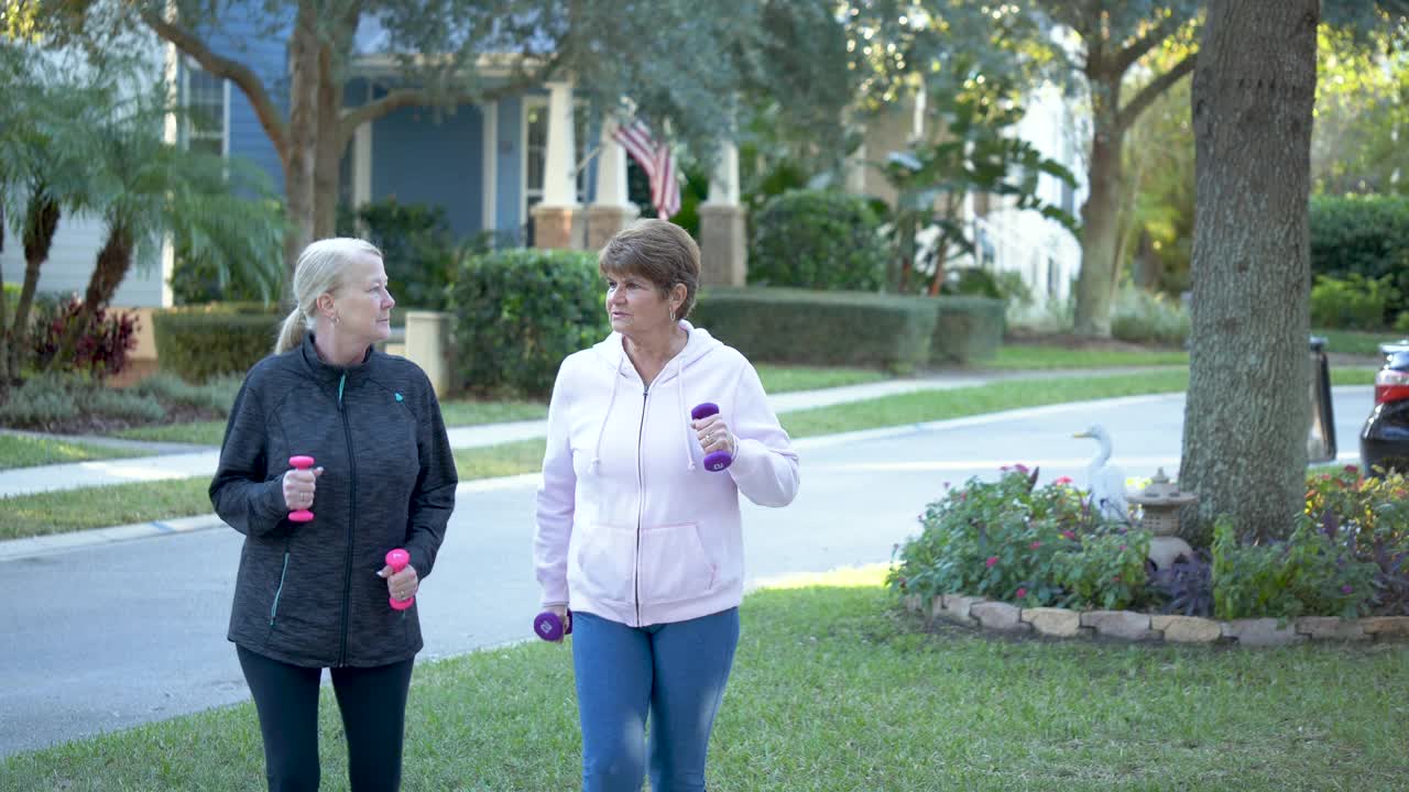 两个老年妇女用哑铃走路视频下载