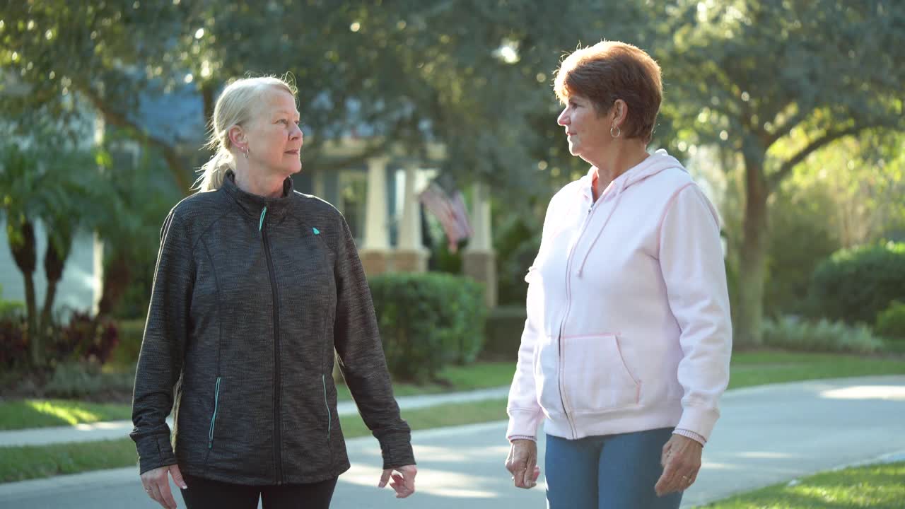 两个老年妇女在车道上锻炼时聊天视频下载