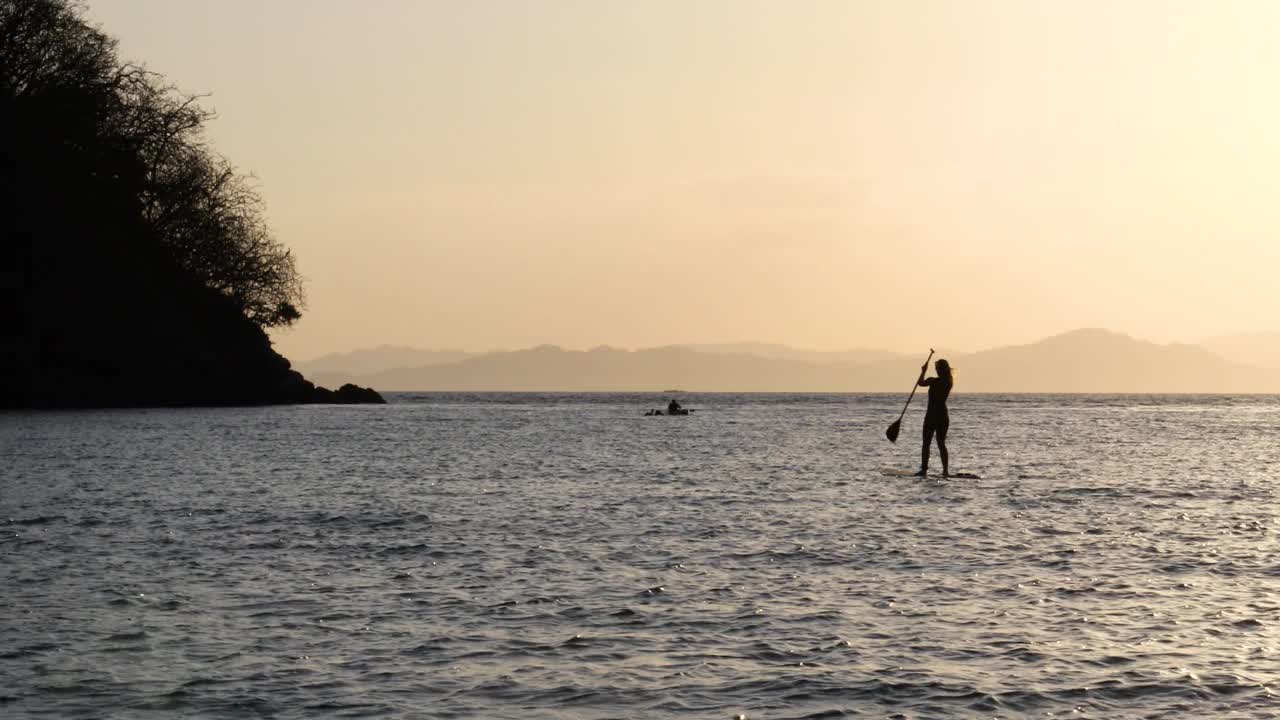年轻女子站桨板(sup)在公海上视频素材