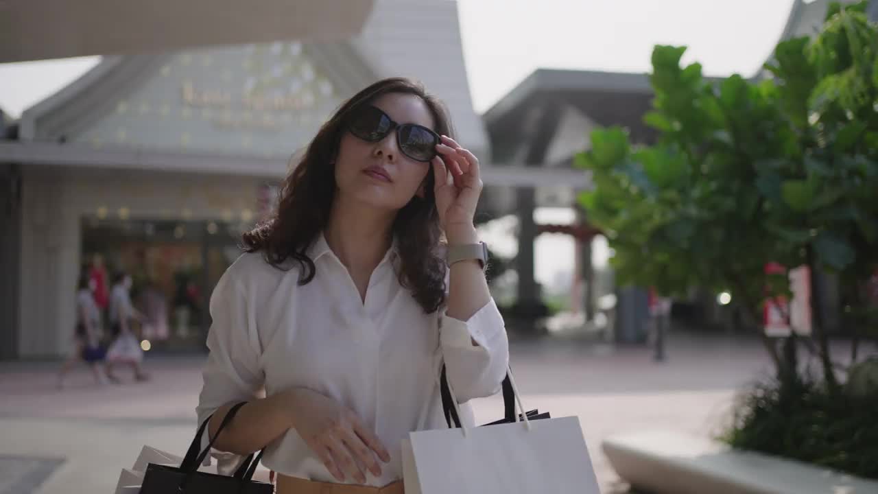 快乐的亚洲女人购物与购物袋视频素材