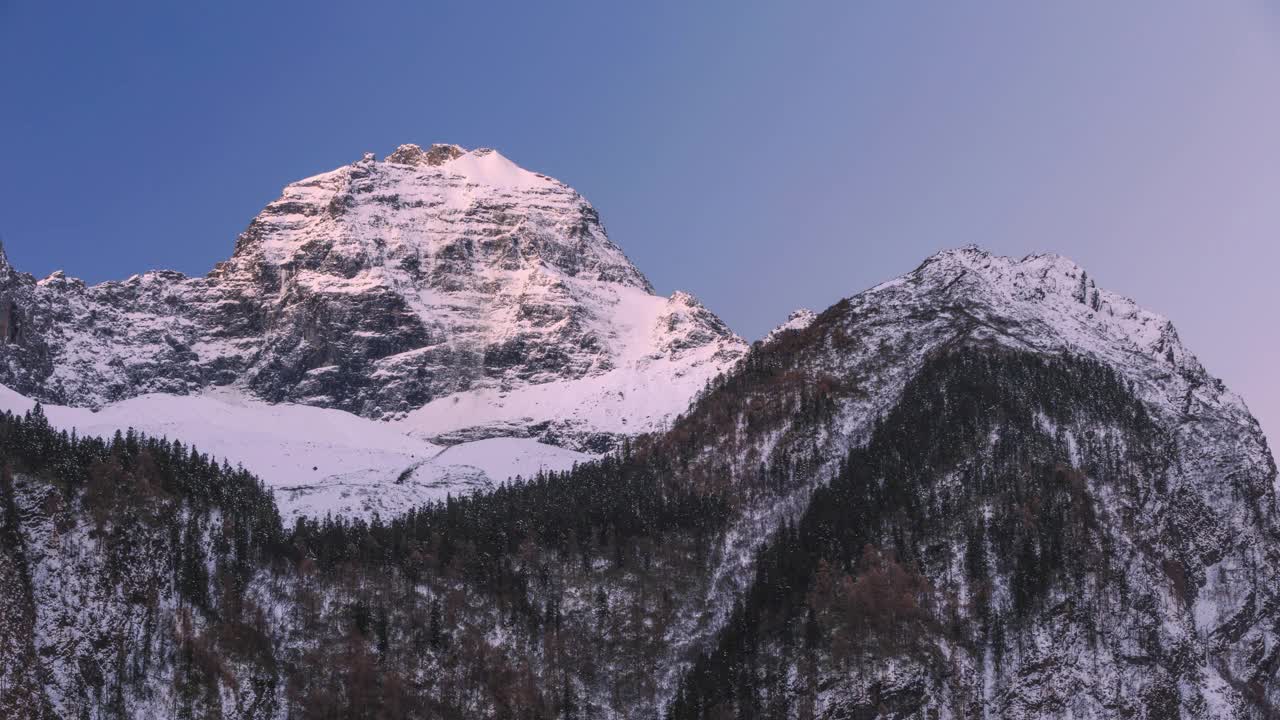 初升的太阳慢慢地照亮了雪山的山顶视频素材