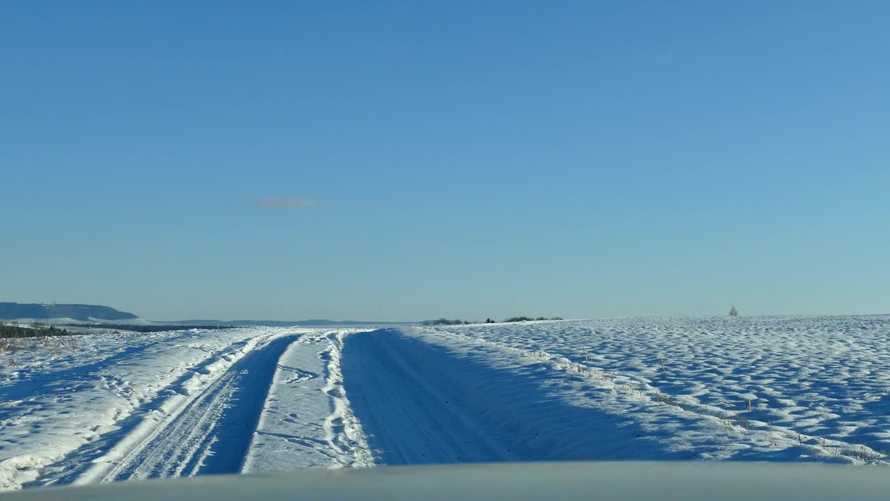 阳光明媚的骑行在白雪覆盖的乡村道路上视频下载