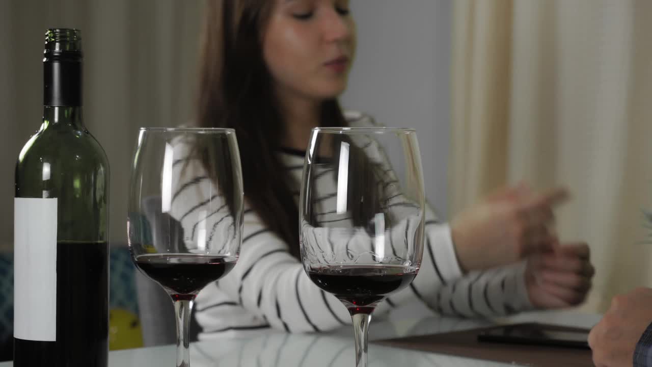 一个男人和一个女人正在家里喝红酒。女人说了些什么视频下载