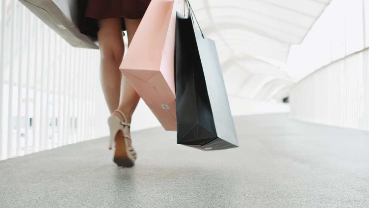 自信的女人走在购物中心购物袋视频下载