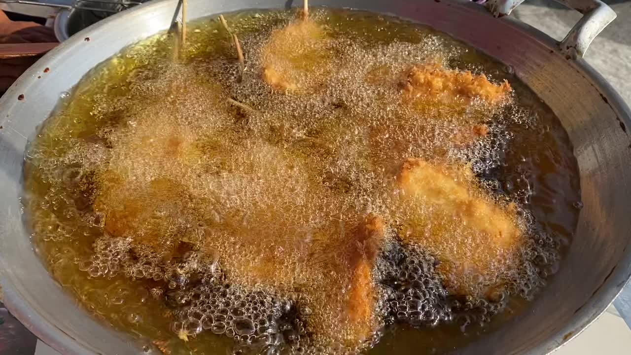 在热油锅里压碎的鸡肉。视频下载